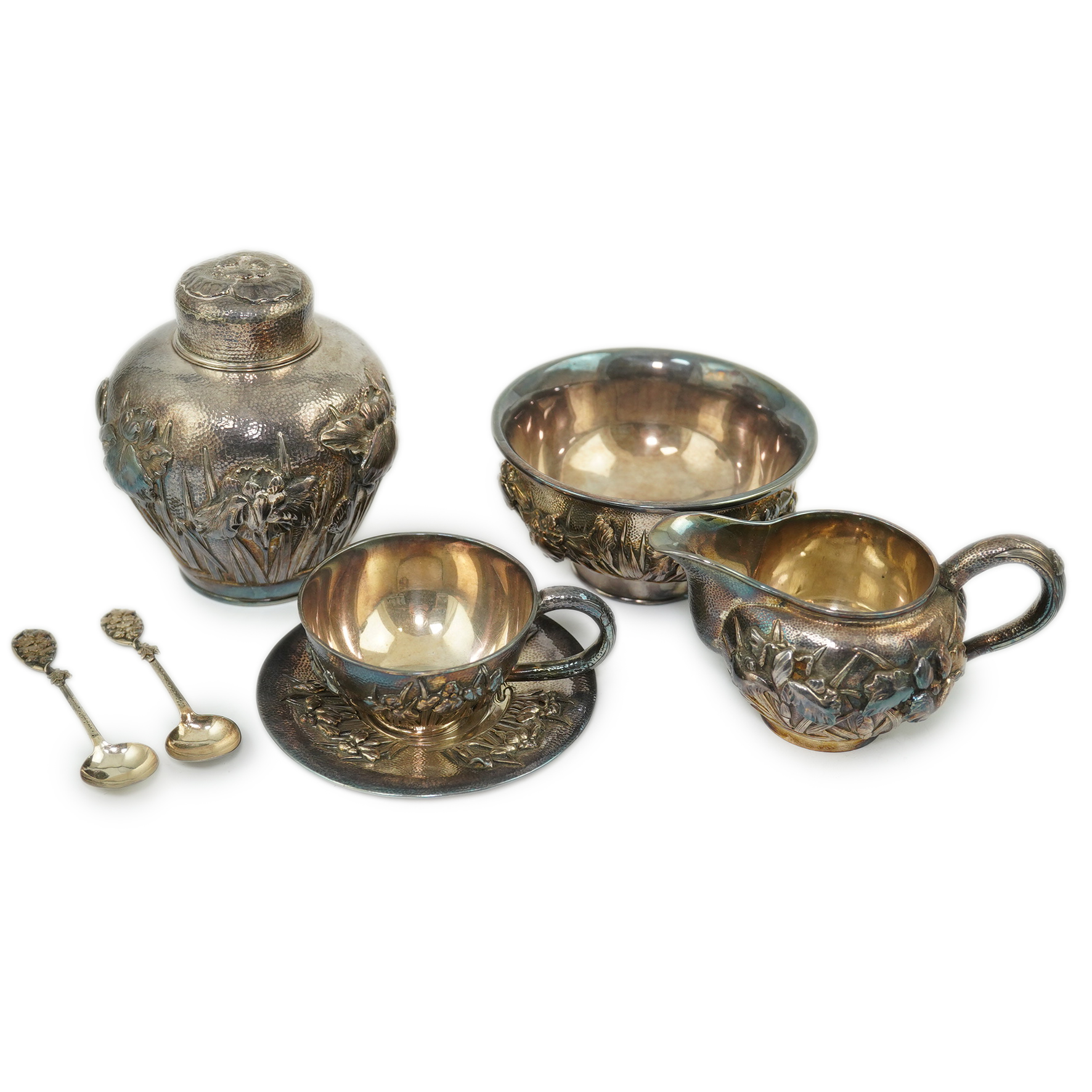 An early 20th century Japanese Meiji period planished silver matched? part tea set comprising a tea caddy with covers, sugar bowl, cream jug and tea cup and saucer